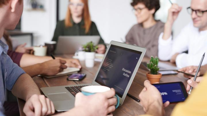 group of people meeitng at a table to discuss