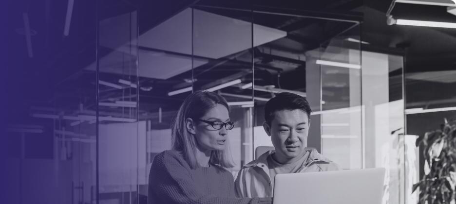 Two people reviewing work on a computer